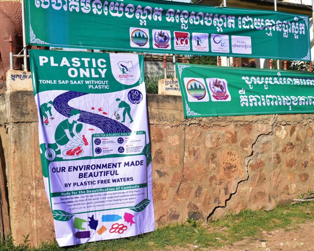 A bilingual Plastic Only poster and a Khmer banner on a wall