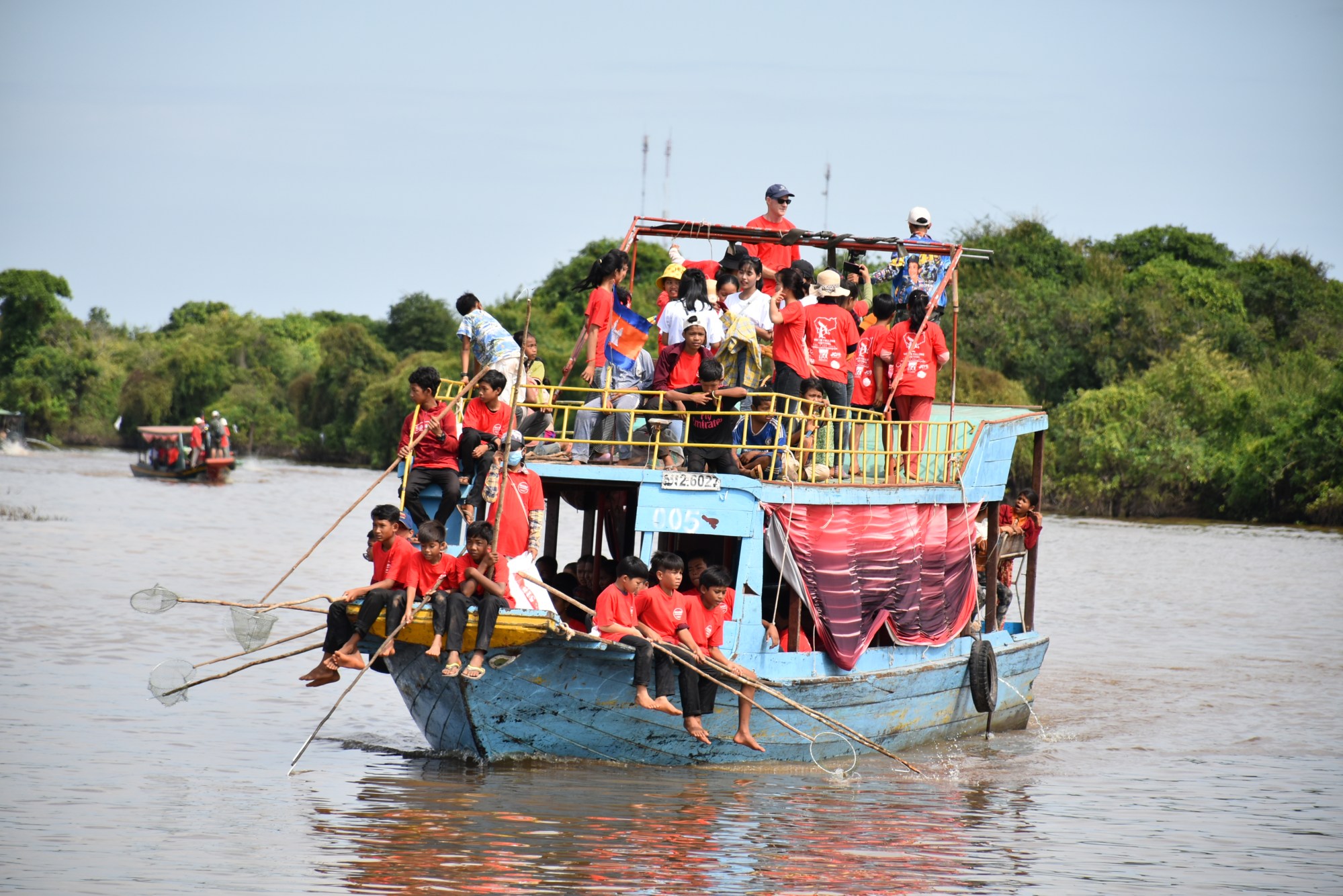 A boat full of volunteers in red shirts on the lake