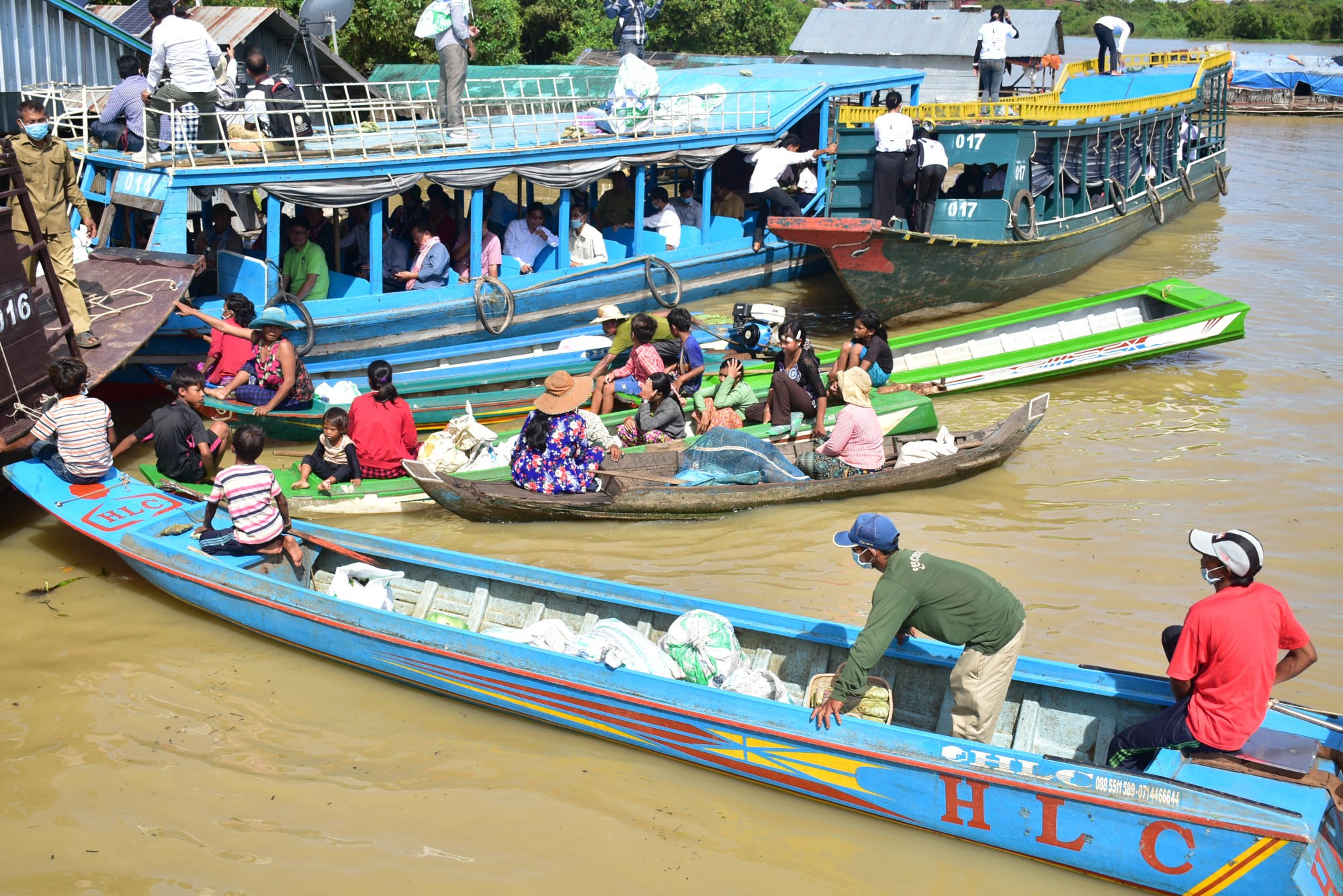 Boats loaded with bags of collected plastic moored at a floating village